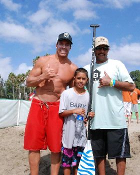 Riggs surfing his prone Bark board at the end of 10 mile race,  Riggs with Aaron and Chuck